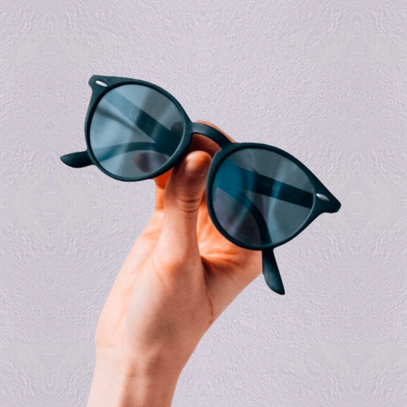 Stylish round sunglasses with black frames held in a hand, available at all-in-1store.com for fashion-forward eyewear shoppers.