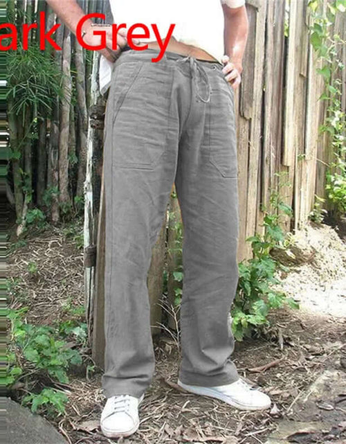 Load image into Gallery viewer, Dark grey summer men&#39;s cotton linen trousers with elastic waist, shown in a casual outdoor setting.
