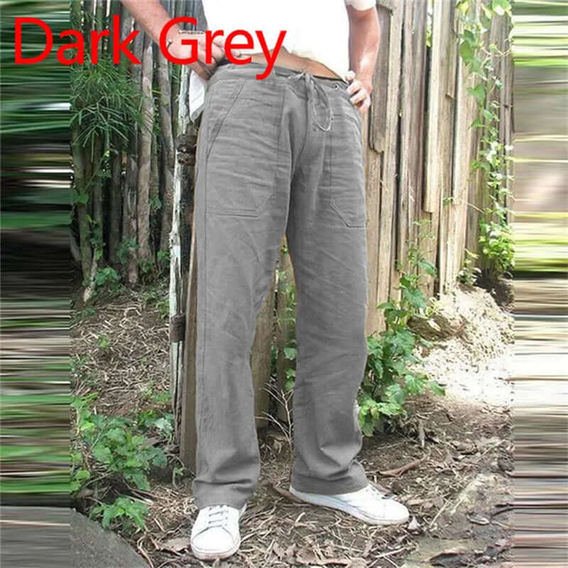 Dark grey summer men's cotton linen trousers with elastic waist, shown in a casual outdoor setting.