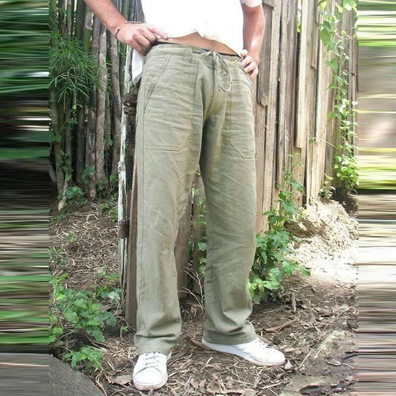 Men's green cotton linen trousers with elastic waist, casual summer style, modeled outdoors among greenery.